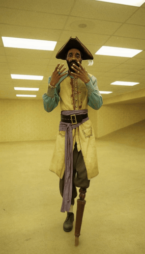 A Man In A Pirate Costume With A Prosthetic Leg Stands In An Empty Room GIF