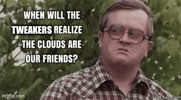 A Man In A Plaid Shirt And Glasses Is Making A Funny Face While Standing In Front Of A Tree . GIF