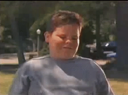 A Man In A Plaid Shirt And Red Pants Is Holding A Can Of Soda In His Hand . GIF