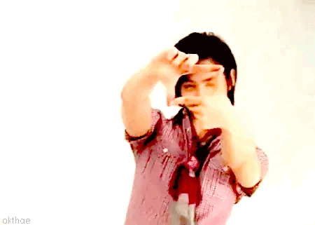 A Man In A Plaid Shirt And Tie Is Making A Frame With His Hands GIF