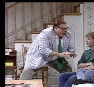 A Man In A Plaid Shirt And Tie Is Standing In Front Of A Man In A Green Shirt GIF