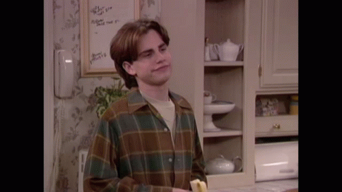 A Man In A Plaid Shirt Is Holding A Banana GIF