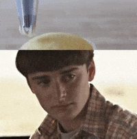 A Man In A Plaid Shirt Is Looking At The Camera With A Pen On His Head GIF