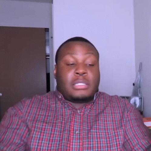 A Man In A Plaid Shirt Is Making A Face GIF
