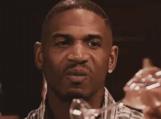 A Man In A Plaid Shirt Is Making A Funny Face . GIF