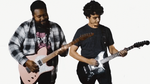 A Man In A Plaid Shirt Is Playing A Guitar Next To Another Man GIF