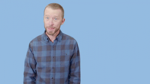 A Man In A Plaid Shirt Is Pointing Up And The Words Brilliant Are Behind Him GIF