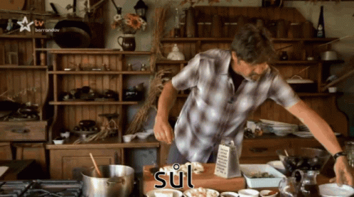 A Man In A Plaid Shirt Is Preparing Food In A Kitchen With The Word Sul Written On The Counter GIF