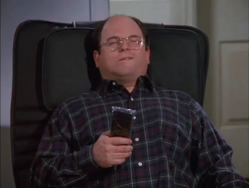A Man In A Plaid Shirt Is Sitting In A Chair With His Eyes Closed And Holding A Bag Of Food GIF