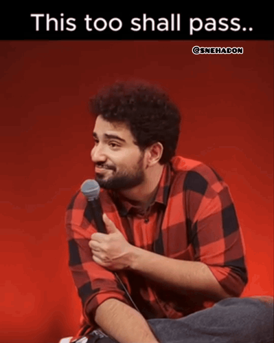 A Man In A Plaid Shirt Is Sitting In Front Of A Microphone With The Caption " This Too Shall Pass " GIF