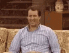 Man Sitting On Couch In Plaid Shirt GIF