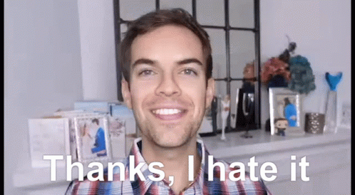 A Man In A Plaid Shirt Is Smiling And Saying Thanks , I Hate It GIF