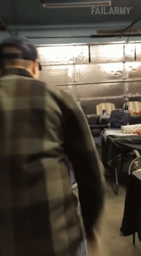 A Man In A Plaid Shirt Is Standing In A Garage With Failarmy Written On The Bottom Of The Screen GIF