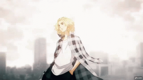 A Man In A Plaid Shirt Is Standing In Front Of A City Skyline With His Hands In His Pockets . GIF