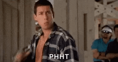 A Man In A Plaid Shirt Is Standing In Front Of A Group Of Men In A Room . GIF
