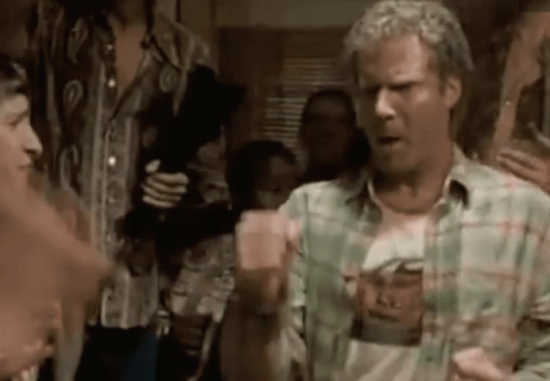 a man in a plaid shirt is standing in front of a group of people .
