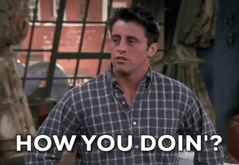 A Man In A Plaid Shirt Is Standing In Front Of A Window And Asking How You Doin ' ? GIF