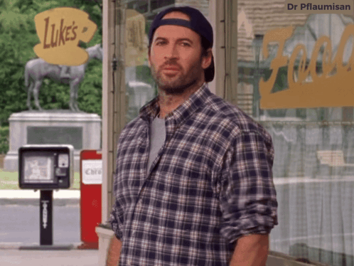 A Man In A Plaid Shirt Is Standing In Front Of Luke 'S GIF