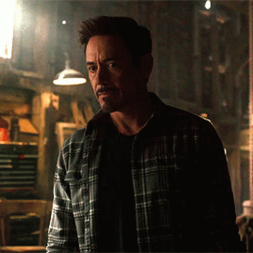 Man In Plaid Shirt Standing In Darkness GIF