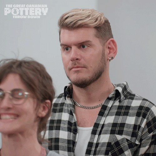 A Man In A Plaid Shirt Is Standing Next To A Woman With Glasses And The Words The Great Canadian Pottery Throw Down GIF