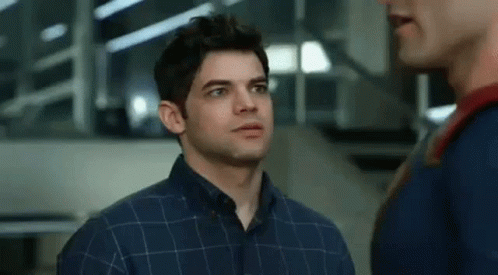 A Man In A Plaid Shirt Is Standing Next To Another Man In A Superman Costume . GIF