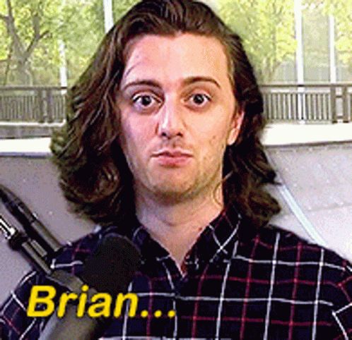 A Man In A Plaid Shirt Is Talking Into A Microphone And The Name Brian Is On The Bottom Right GIF