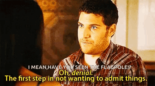 a man in a plaid shirt is talking to a woman in a room .