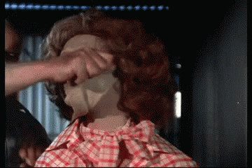 A Man In A Plaid Shirt Is Touching A Woman 'S Face GIF