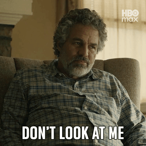 A Man In A Plaid Shirt Sits In A Chair With The Words " Don 'T Look At Me " Written Below Him GIF