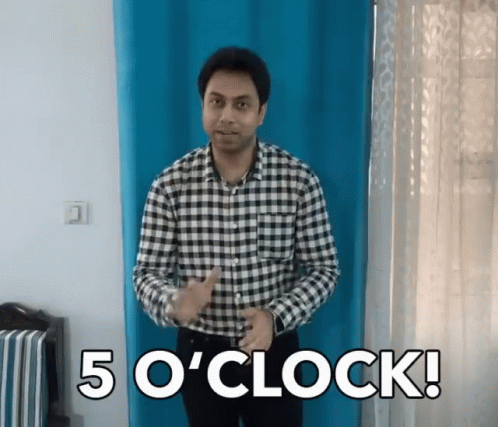 A Man In A Plaid Shirt Stands In Front Of A Blue Curtain And Says " 5 O ' Clock " GIF