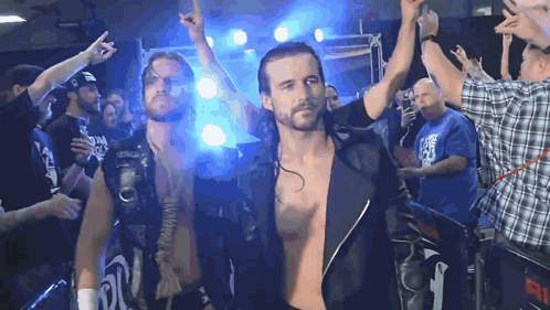 A Man In A Plaid Shirt Stands In Front Of A Crowd With The Number 91 On The Back GIF