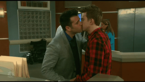 A Man In A Plaid Shirt Talks To A Man In A Suit GIF