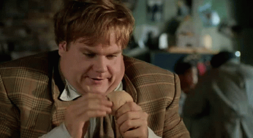 A Man In A Plaid Suit Is Eating A Hot Dog GIF