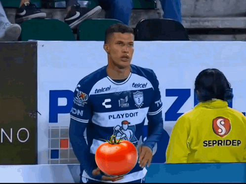 A Man In A Playdoit Jersey Holds A Tomato In His Hands GIF