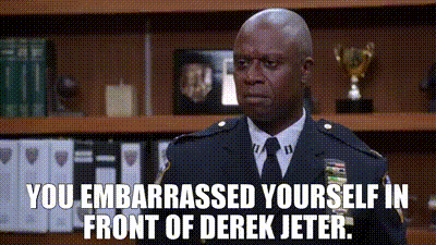 A Man In A Police Uniform And Tie Is Standing In Front Of A Bookshelf And A Trophy . GIF