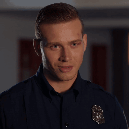 A Man In A Police Uniform Is Standing In Front Of A Box GIF