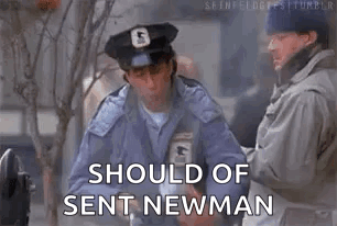 A Man In A Police Uniform Is Standing Next To Another Man And Holding A Box . GIF