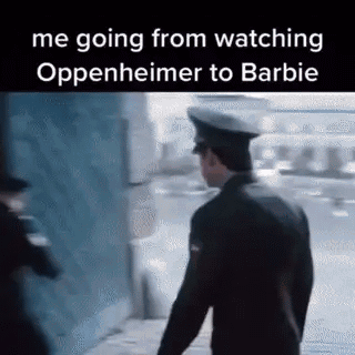 A Man In A Police Uniform Is Walking Down A Sidewalk Next To A Building . GIF