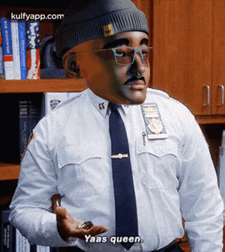A Man In A Police Uniform Says Yaas Queen While Holding Something In His Hand GIF