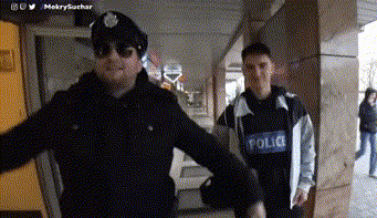A Man In A Police Uniform Stands Next To Another Man GIF