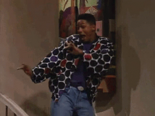 A Man In A Polka Dot Jacket Is Standing In Front Of A Painting GIF