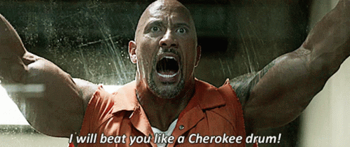 A Man In A Prison Uniform Says I Will Beat You Like A Cherokee Drum GIF