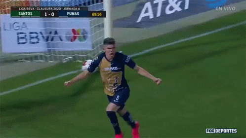 a man in a pumas jersey celebrates a goal on a soccer field