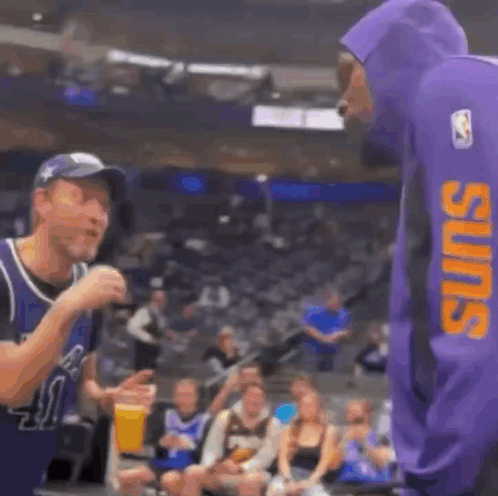 A Man In A Purple Hoodie Is Standing Next To A Basketball Player In A Purple Hoodie . GIF