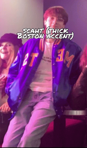 A Man In A Purple Jacket With The Letters Tm On It GIF