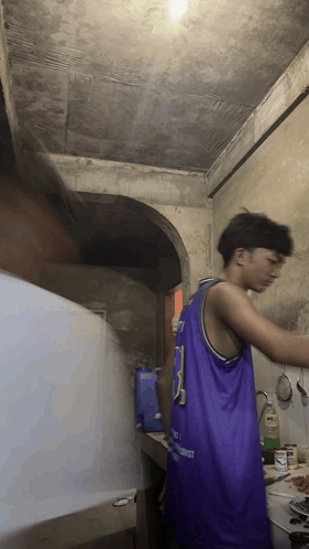 A Man In A Purple Jersey With The Number 3 On It Is Cooking In A Kitchen GIF