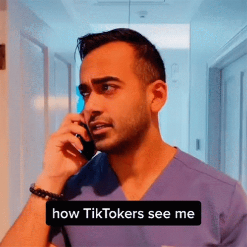 A Man In A Purple Scrub Is Talking On A Cell Phone And Says " How Tiktokers See Me " GIF