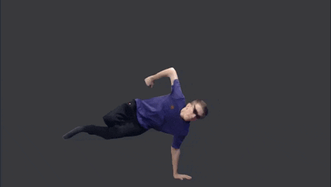 a man in a purple shirt and black pants is doing a handstand on a black background .