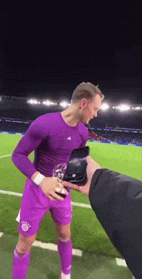 a man in a purple shirt and purple shorts holds a trophy