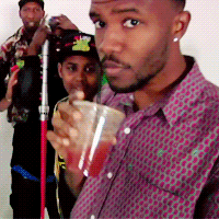 A Man In A Purple Shirt Holds A Cup Of Red Liquid GIF